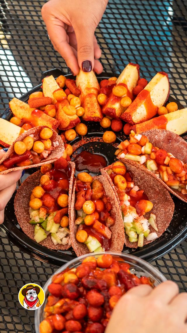 Charola con tacos de jícama, fruta y botanas con chamoy para compartir